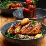 Delicious roasted chicken breast with potatoes and fresh salad in elegant bowls.