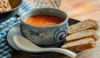 Delicious East European solyanka soup served with bread, perfect for a cozy meal.