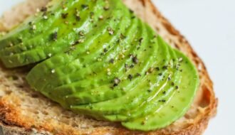 Sliced avocado atop sourdough bread, seasoned with pepper, photographed for a food photography series.