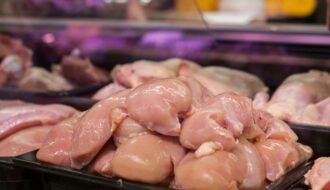 Fresh raw chicken breasts displayed in a supermarket setting, ready for purchase.