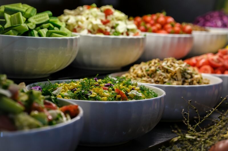 A colorful assortment of fresh salads and vegetables in ceramic bowls. Perfect for healthy food photography.