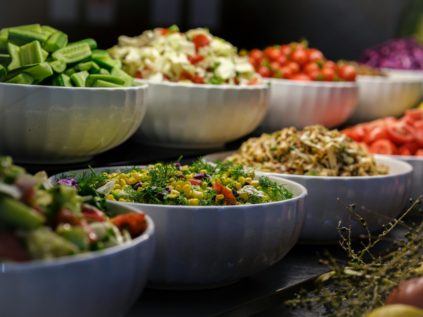 A colorful assortment of fresh salads and vegetables in ceramic bowls. Perfect for healthy food photography.